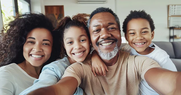 Família sorrindo reunida no sofá com o prontuário vivo AR Vital protegendo quem eles amam